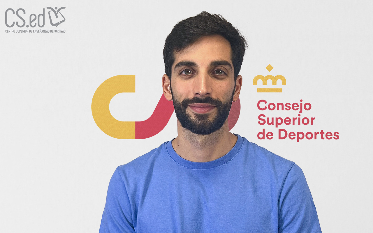 La imagen muestra a un hombre joven con barba mirando a la cámara. Lleva una camiseta azul. Detrás de él se ve un logo del Centro Superior de Enseñanzas Deportivas y del Consejo Superior de Deportes