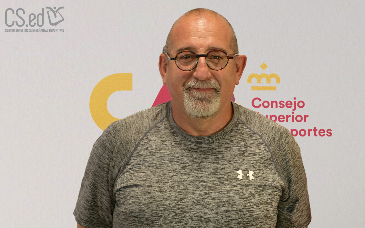 La imagen muestra un retrato de un hombre de mediana edad con gafas. Lleva una camiseta gris. El fondo es blanco con el logotipo del Consejo Superior de Deportesen la parte superior derecha